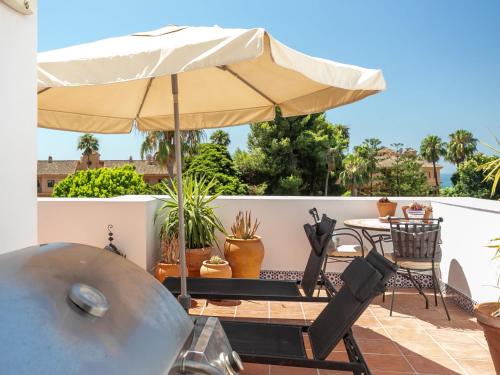 a patio with an umbrella and a table and chairs at Holiday Home Sol de Estepona by Interhome in Estepona