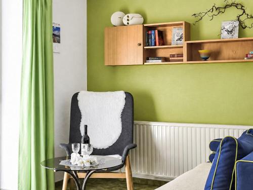 a green room with a chair and a glass table at Apartment Siebers by Interhome in Sebnitz