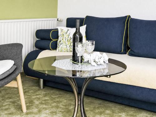 a glass table with a bottle of wine and glasses at Apartment Siebers by Interhome in Sebnitz