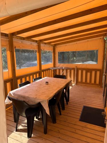 a wooden table and chairs on a wooden deck at Bahia 2 in Le Faulq