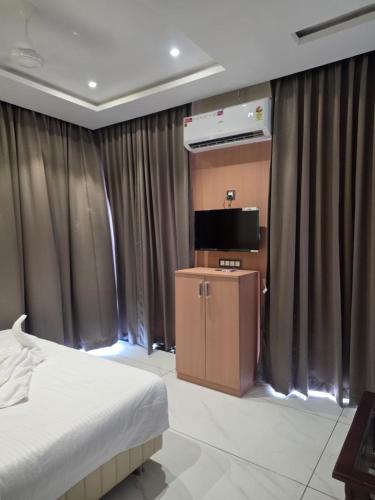 a bedroom with a bed and a flat screen tv at Hotel Nandanwan Resto and Bar in Mālsiras
