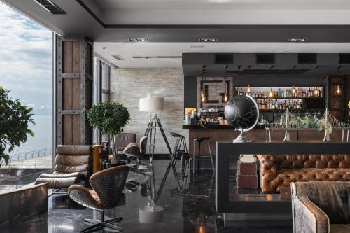 a room with a bar with chairs and a window at M1 Club Hotel in Odesa