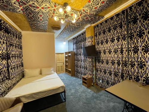 a room with a bed and a wall covered in wallpaper at Mulberry Hotel in Tashkent