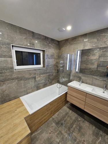 a bathroom with a tub and a sink and a tv at Vila Castrum in Nové Zámky