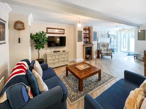 a living room with a blue couch and a table at St Augustine's Stays - Stone Bay in Broadstairs