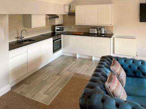 a living room with a blue couch in a kitchen at Periwinkle No5 - Uk49249 in Althorne