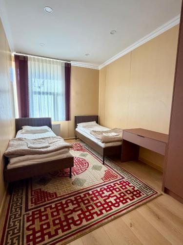 ein Schlafzimmer mit zwei Betten und einem Teppich in der Unterkunft Sunpath Mongolia Tour & Hostel in Ulaanbaatar