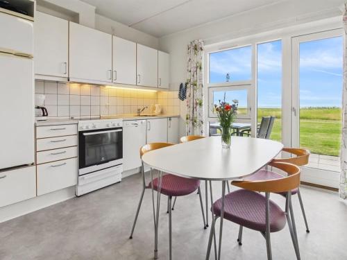 a kitchen with a white table and chairs and a table at Apartment Sofija by Interhome in Højer