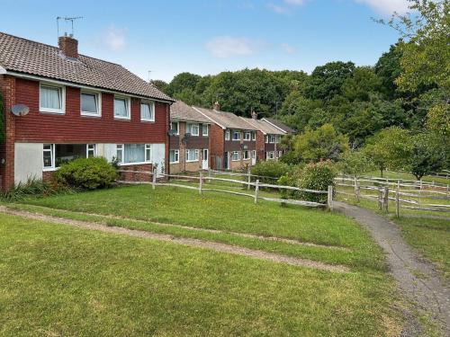 a house with a fence in front of a yard at Views Wood in Uckfield