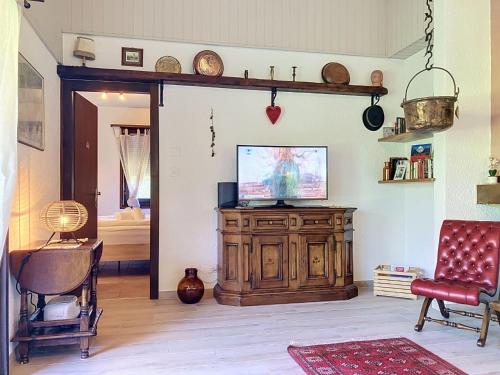 a living room with a television on a wooden cabinet at Holiday Home Dorenavant by Interhome in Bouveret