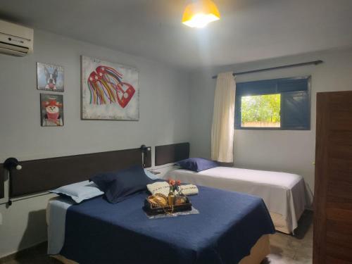 a hotel room with two beds and a window at Urca do Tubarão in Touros