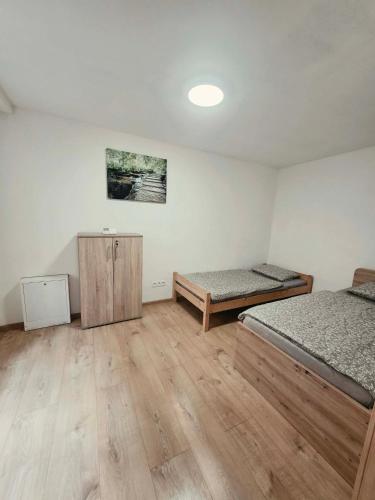 a bedroom with two beds and a wooden floor at Apartmán Gabriel in Kežmarok