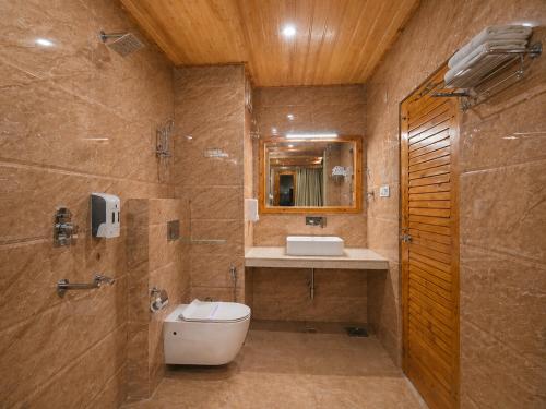 a bathroom with a toilet and a sink at The Tanwar Villas in Manāli