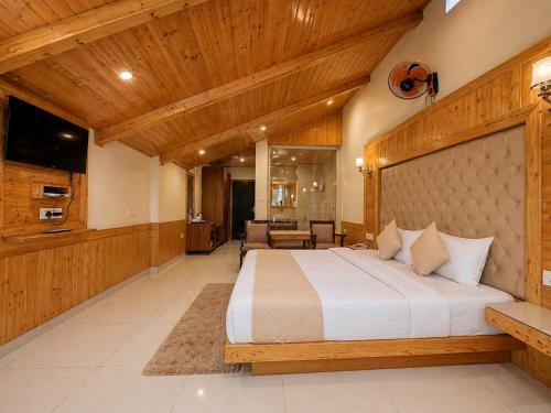 a bedroom with a large bed with a wooden ceiling at The Tanwar Villas in Manāli