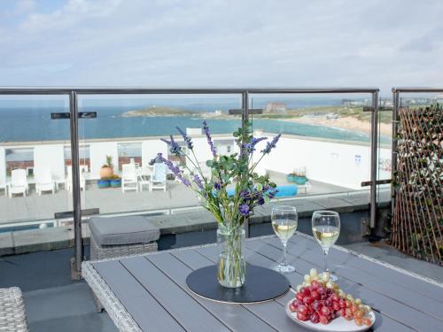 a table with a vase of flowers and glasses of wine at Chacewater in Newquay