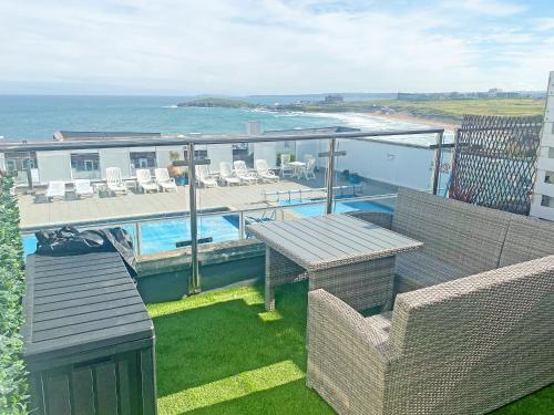a balcony of a house with a swimming pool and the ocean at Chacewater in Newquay
