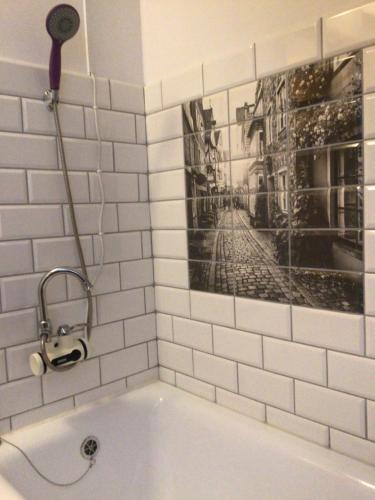 ein Badezimmer mit Badewanne und einem Bild an der Wand in der Unterkunft Folwark Miodobytek in Łomnica