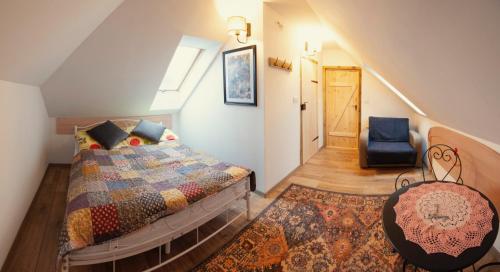 ein Schlafzimmer mit einem Bett und einem blauen Stuhl in der Unterkunft Folwark Miodobytek in Łomnica