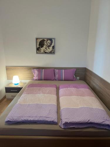 ein Schlafzimmer mit einem Bett mit lila und weißen Decken in der Unterkunft Wilhelmsthal in Wilhelmsthal