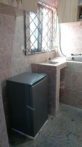 a small kitchen with a sink and a refrigerator at BP Aura Stay in Akitan