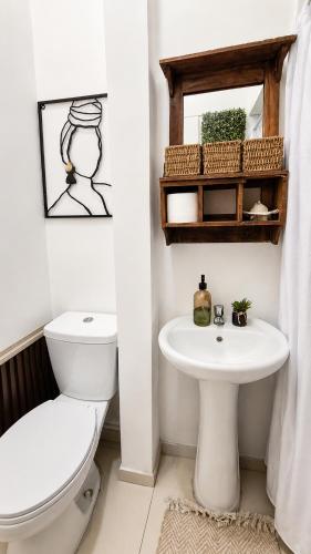 a bathroom with a toilet and a sink at Milagro Andino in Arica
