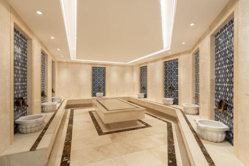 a bathroom with three toilets and a bath tub at Grand Bloom Hotel in Baghdād