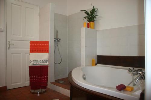 a white bathroom with a tub and a shower at Bleu du Sud in Le Tampon