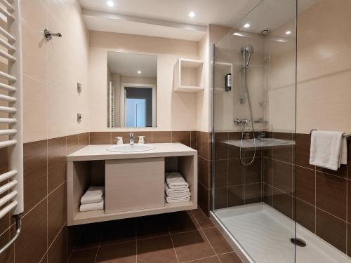 a bathroom with a sink and a shower at The Originals Résidence, Les Strélitzias in Juan-les-Pins