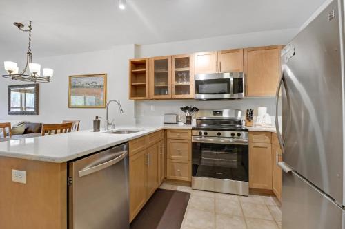 a kitchen with wooden cabinets and a stainless steel refrigerator at CS334 Copper Springs in Copper Mountain