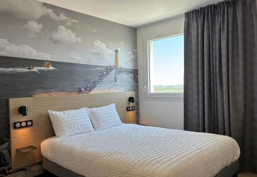 a bedroom with a bed with a painting on the wall at B&B HOTEL Cap d'Agde Bessan in Bessan