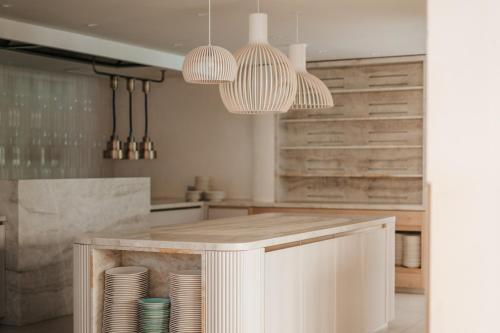 a kitchen with a counter with plates and pendant lights at Sonnen Resort in Naturno