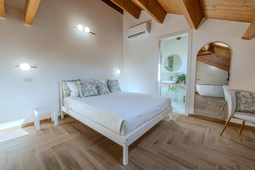 a bedroom with a white bed and a mirror at The White House in Miglianico