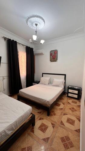 a bedroom with two beds and a chandelier at Hotel islam 1 in Tlemcen