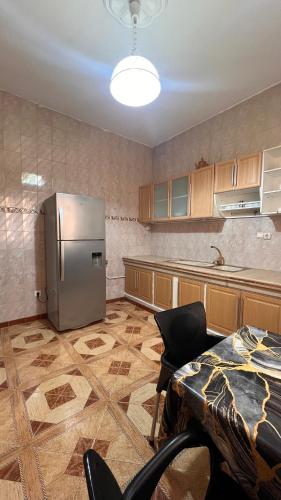 a kitchen with a stainless steel refrigerator and a table at Hotel islam 1 in Tlemcen