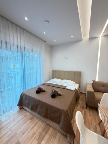 a bedroom with a bed and a couch at Vellora Central Suite in Xanthi