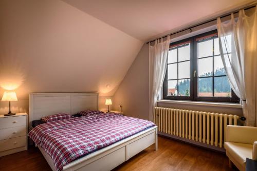 a bedroom with a bed and a large window at Ubytovanie Filloména in Liptovský Ján