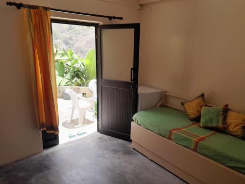 a bedroom with a bed and a door to a patio at Casa Das Ilhas in Paul