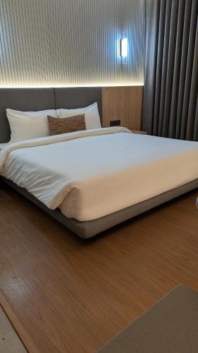 a bedroom with a large bed with white sheets and pillows at Hotel Grande Court in Kharar