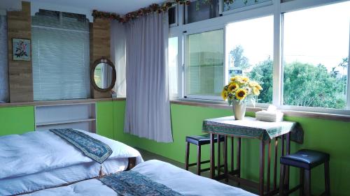 Un dormitorio con una cama y una mesa con flores. en Golden Mary, en Taitung