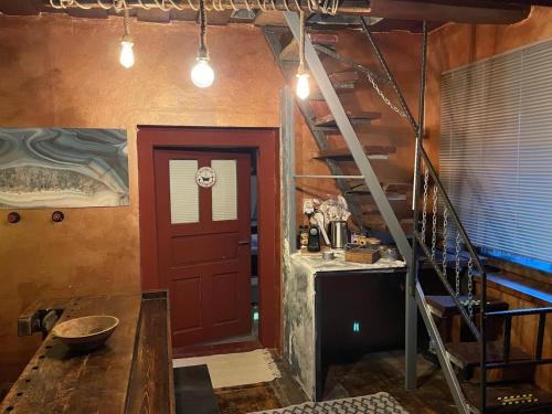 a kitchen with a red door and a spiral staircase at Villa LEA in Ratkovské Bystré