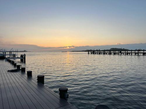 a pier on the water with the sunset in the background at Sunset Getaway in Ocean City
