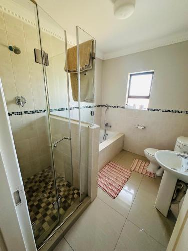 a bathroom with a shower and a toilet and a sink at Kairos Home in Maseru