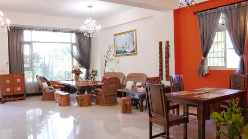 una sala de estar con paredes de color naranja, mesas y sillas. en Golden Mary, en Taitung