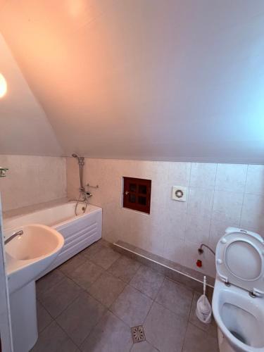 a bathroom with a sink and a toilet and a tub at Tinano in Kuchkisabano