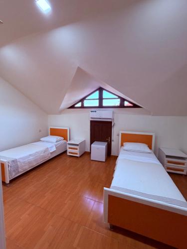 a attic bedroom with two beds and a window at Tinano in Kuchkisabano
