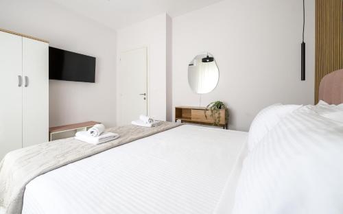 a bedroom with a large white bed with two phones on it at Korina Suites in Perea