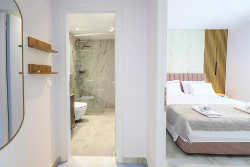 a bedroom with a bed and a bathroom with a shower at Korina Suites in Perea