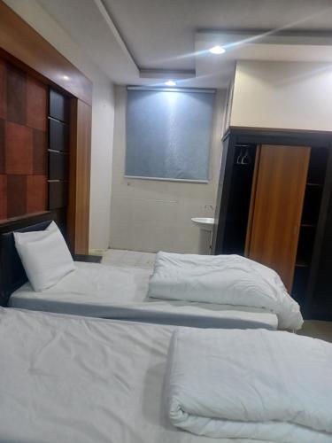a bedroom with two beds and a large window at فندق علي عايض الدوسري in Abu Arish