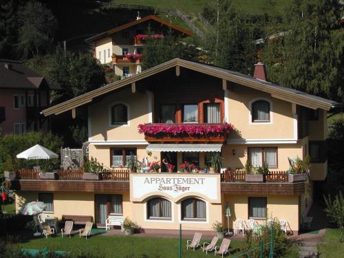 a large building with a balcony with flowers on it at Appartements Landhaus Jäger in Filzmoos