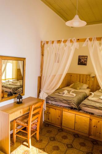 a bedroom with two beds and a desk and a mirror at Villa Soultana in Lindos